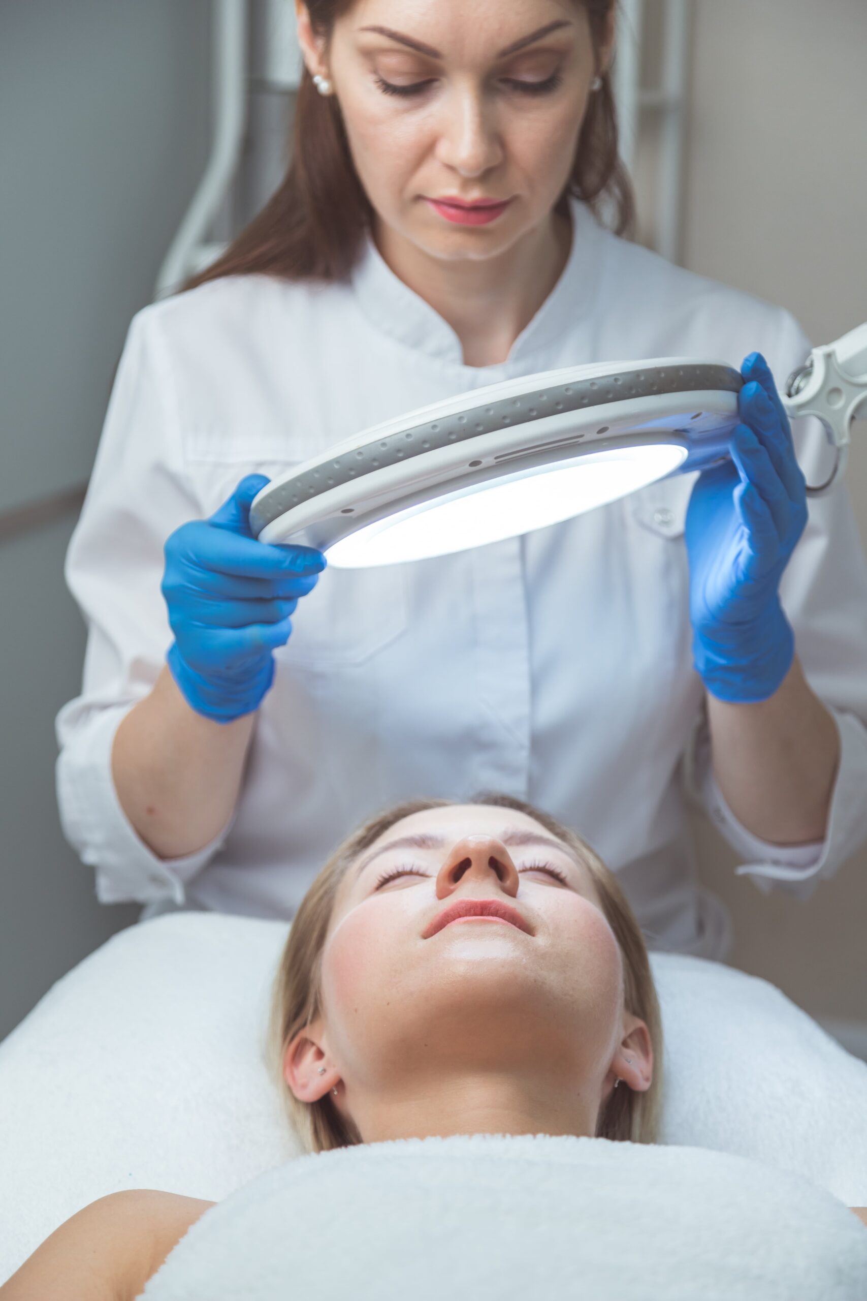 beautician-doctor-is-examining-woman-s-face-with-s-2025-02-12-22-40-48-utc-min Beautician doctor is examining woman's face with special lamp.