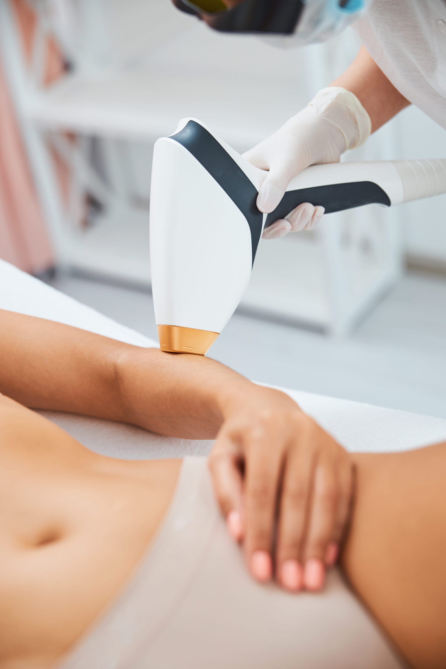 Cosmetician performing an arm laser hair removal.