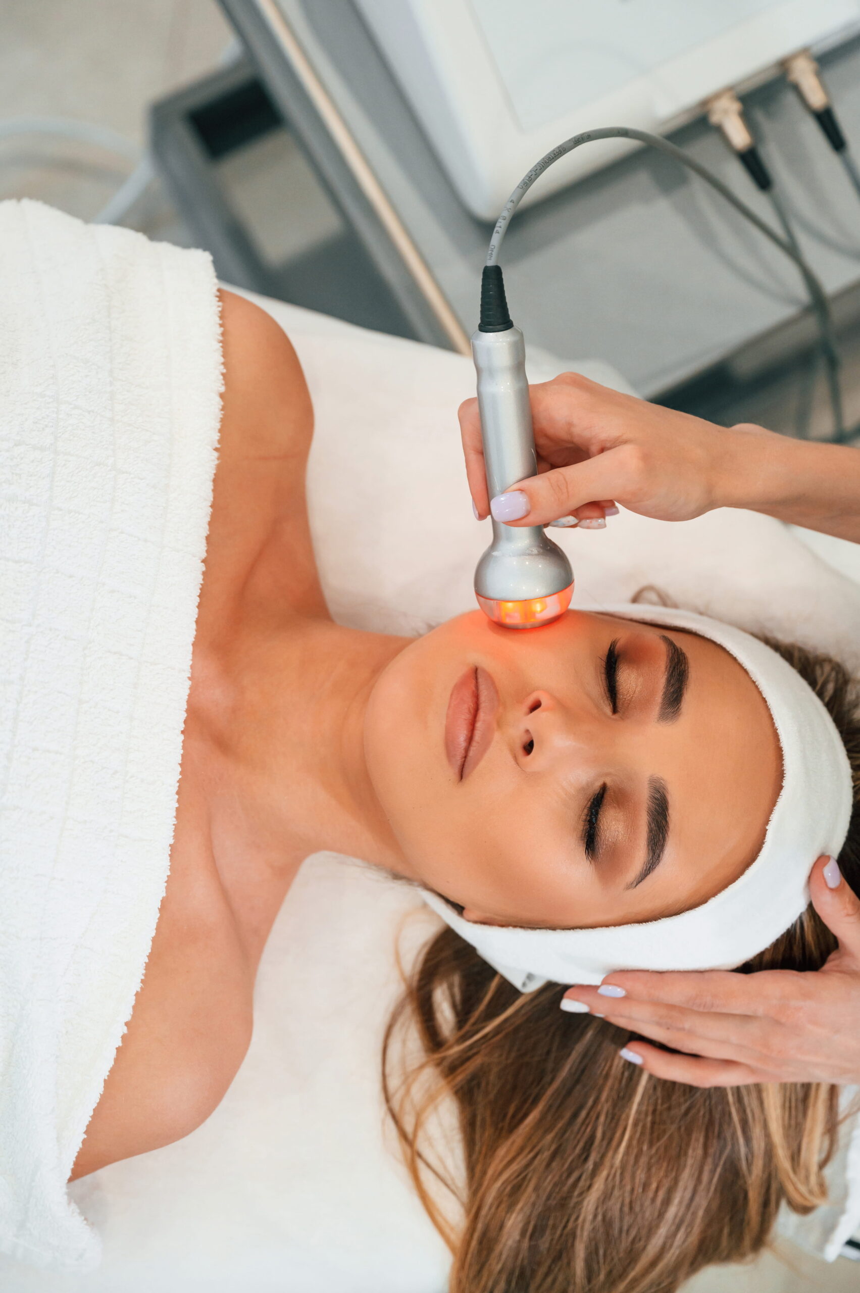 Electrical therapy tool. Woman face getting facial care by beautician hands at spa salon