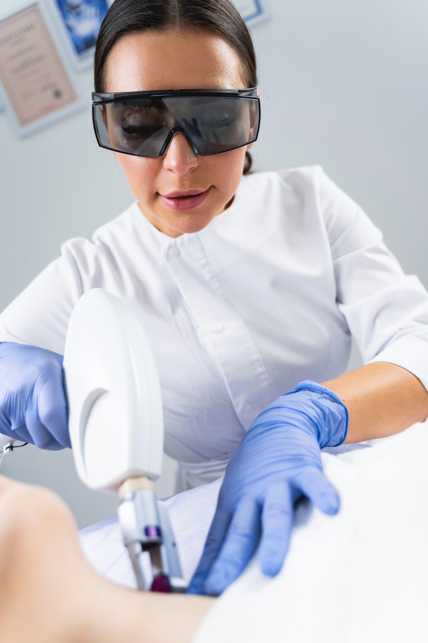 Woman Performing Laser Treatment in Medical Setting