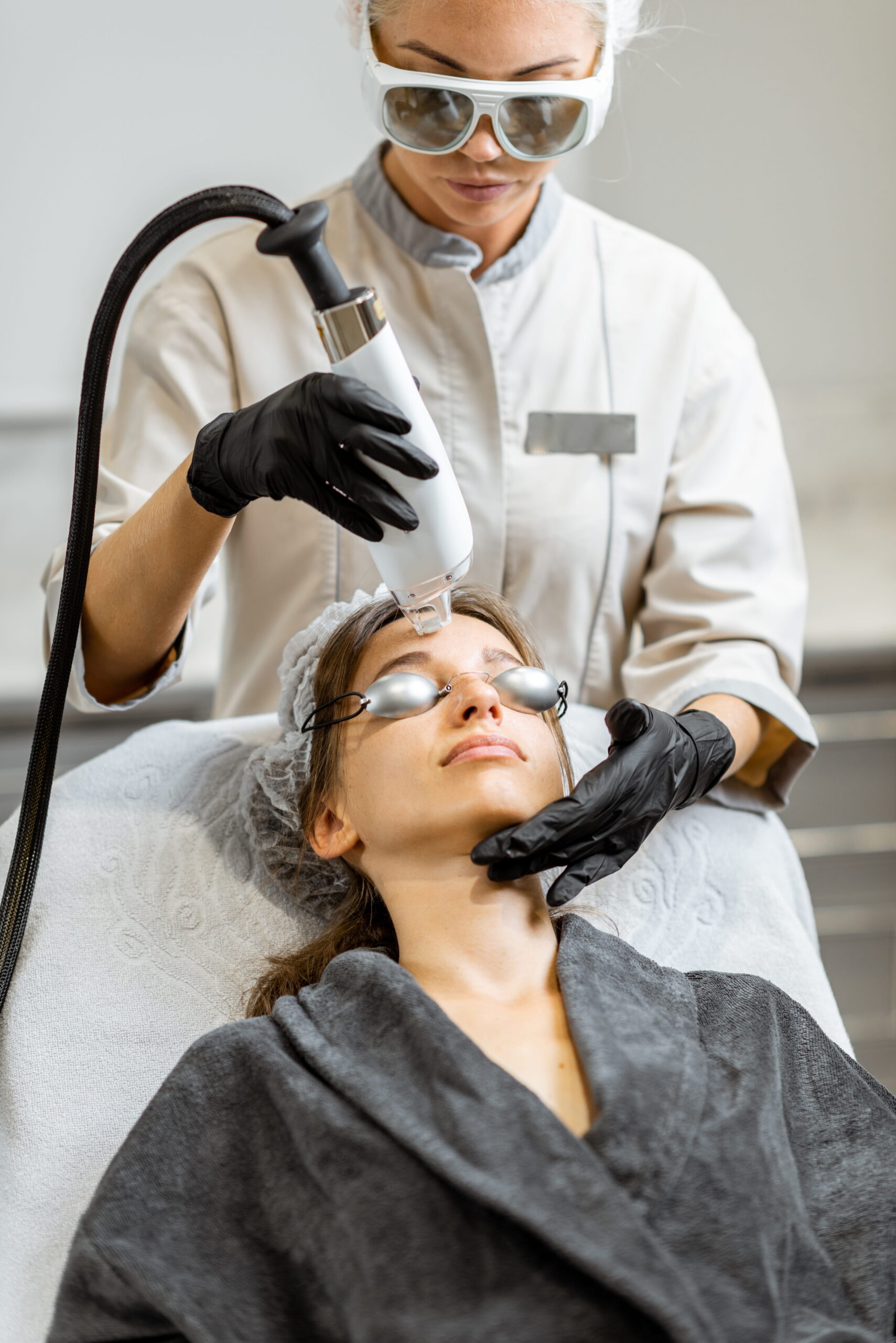 Woman Receiving Laser Facial Treatment in Clinic